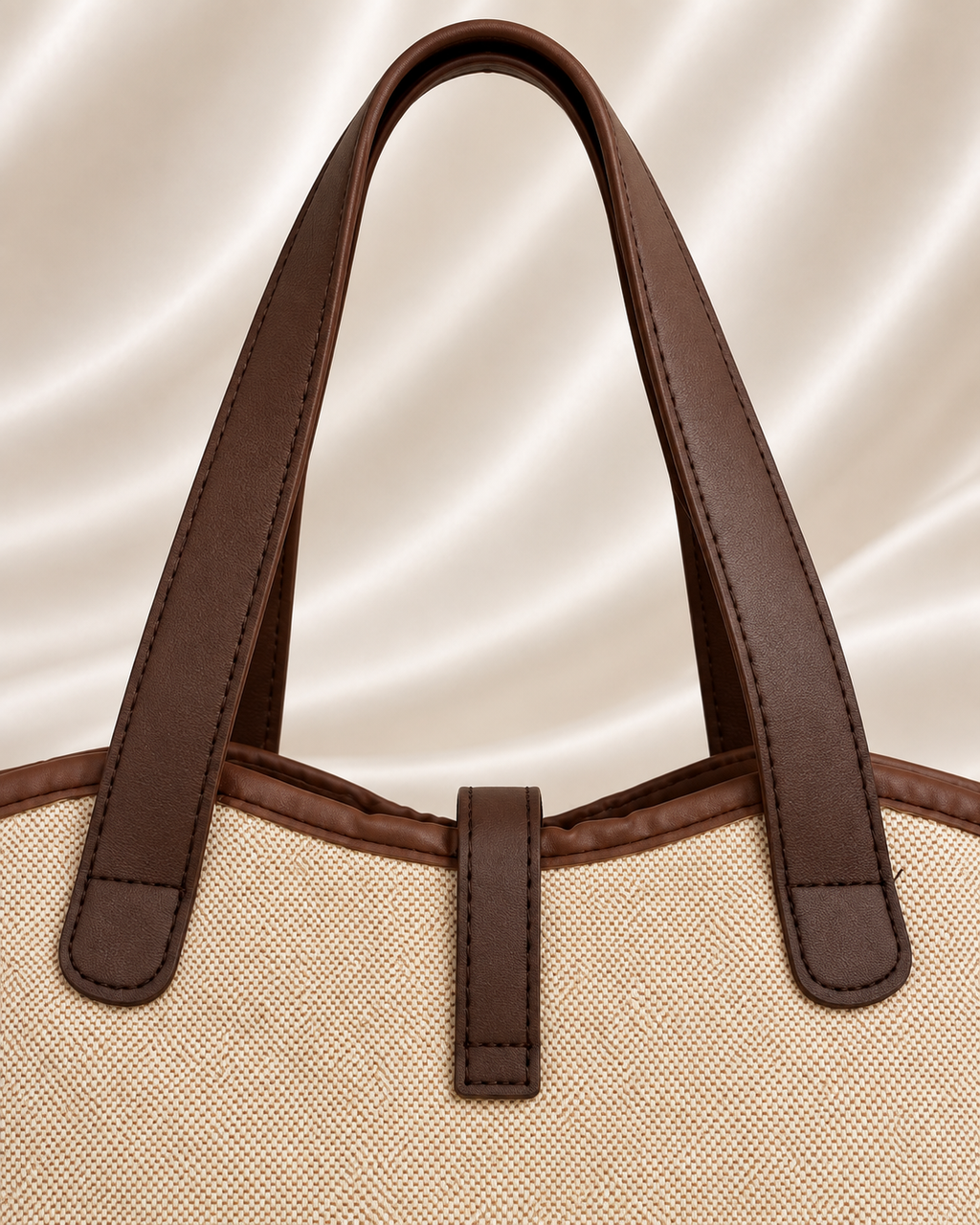 Brown handle and stitching detail of beige woven tote bag