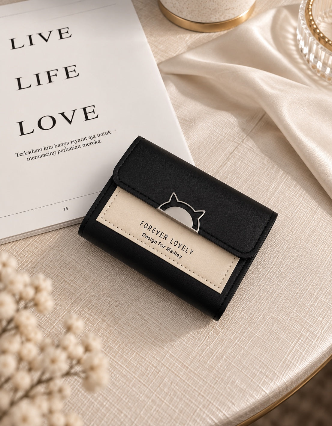 Black and beige compact wallet on cream table setting