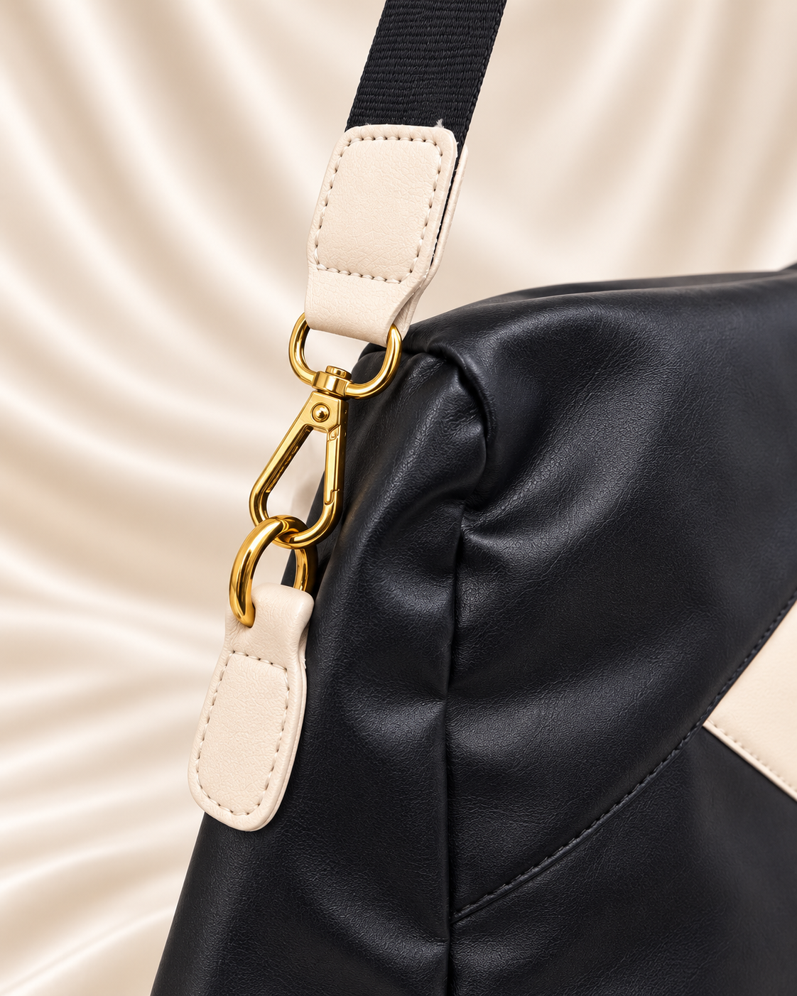 Black and cream bag strap and gold hardware close-up