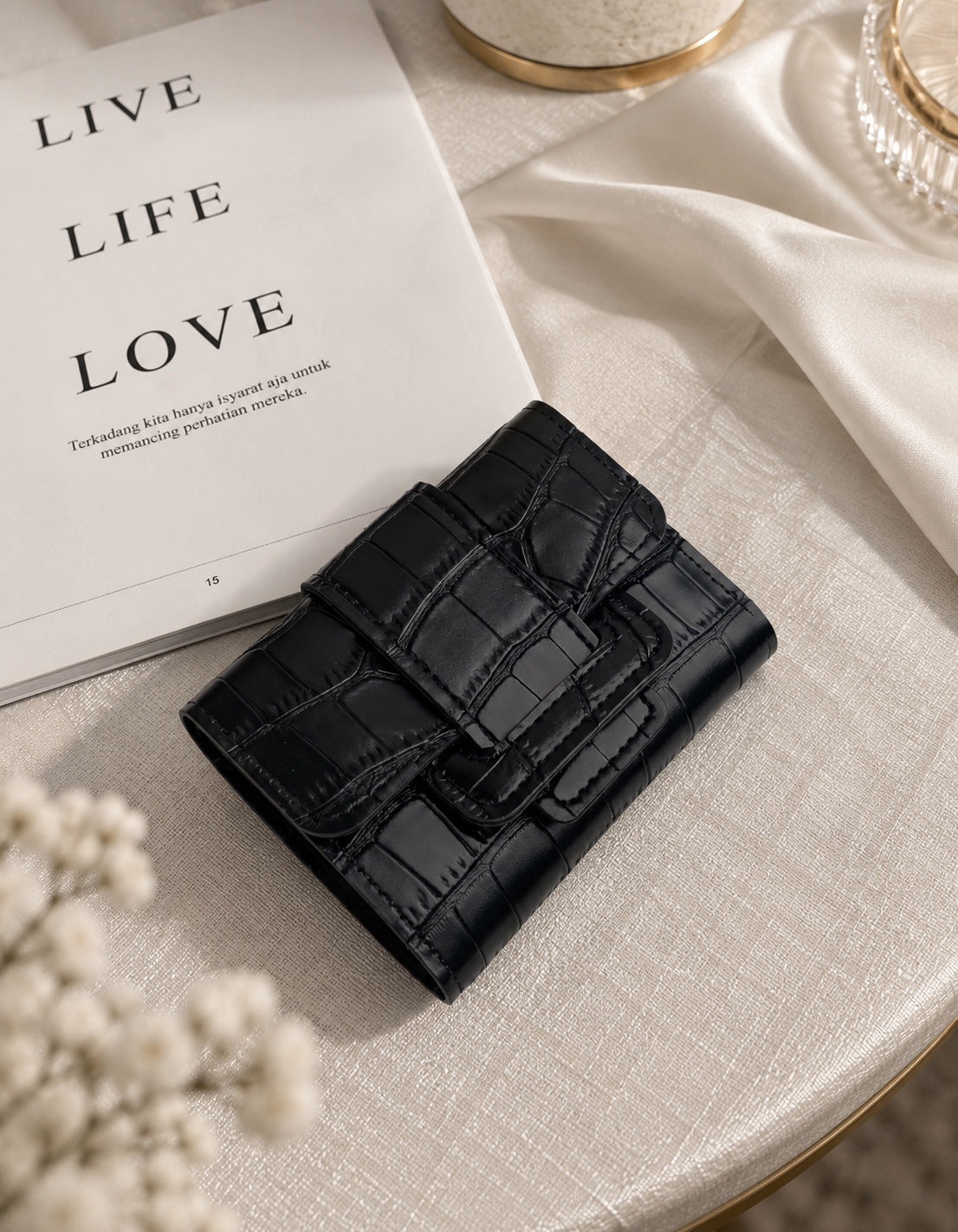 Black crocodile texture wallet on cream table setting