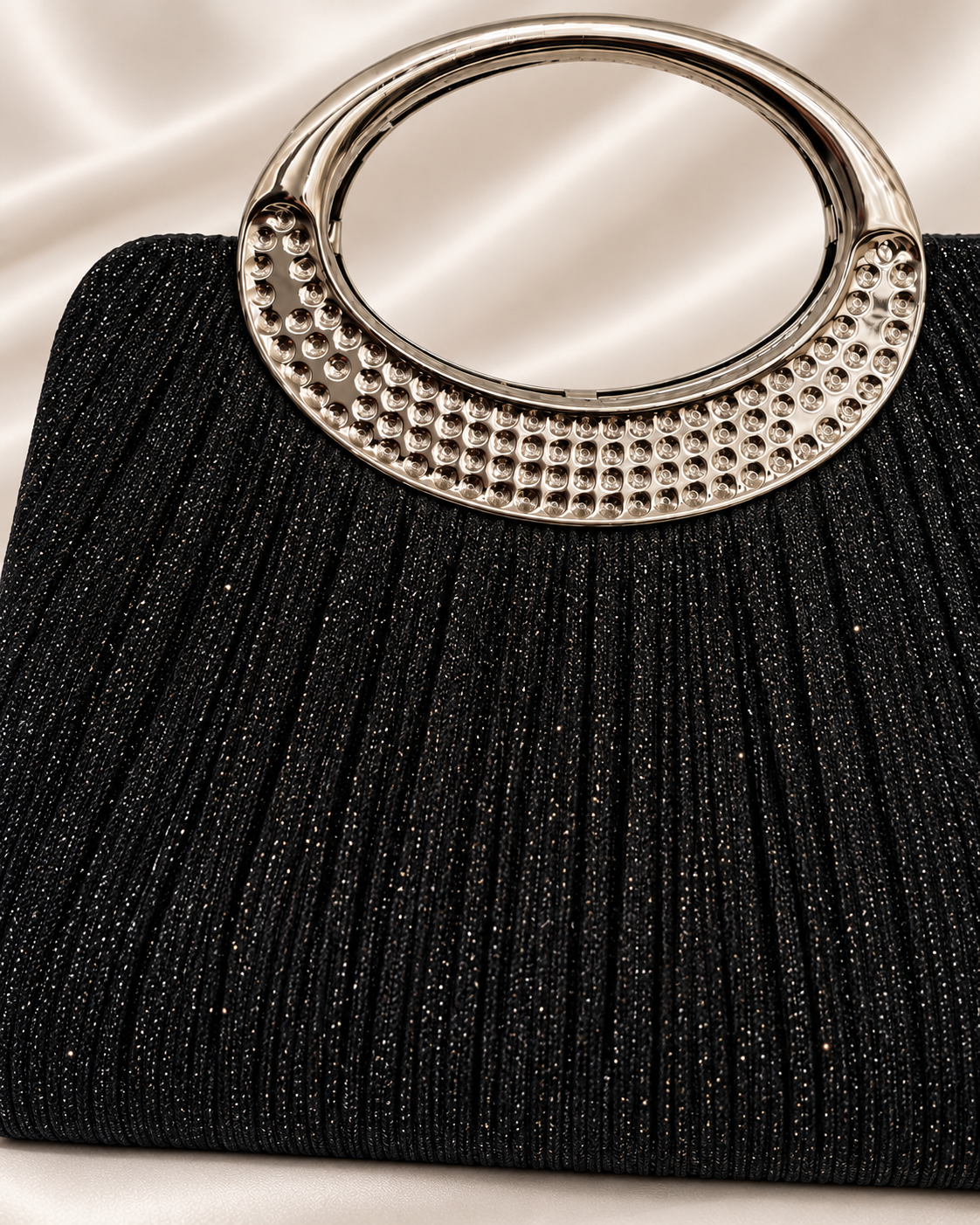 Close-up of front pleated glitter fabric and silver oval handle