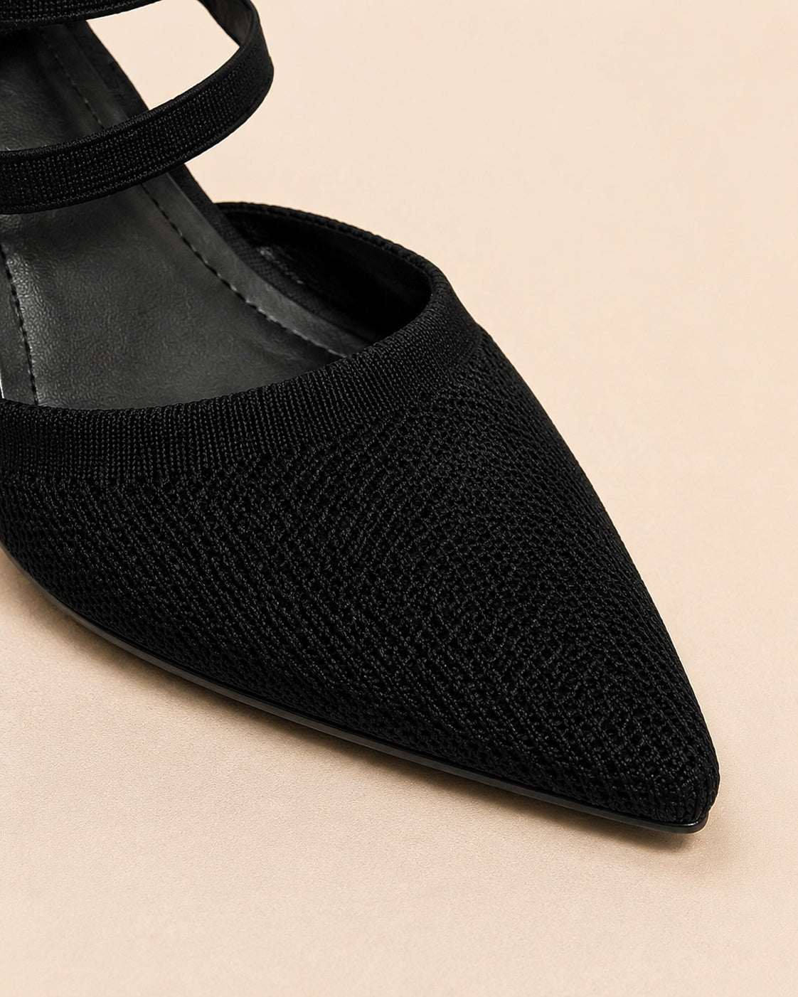 Black pointed-toe heel toe texture detail