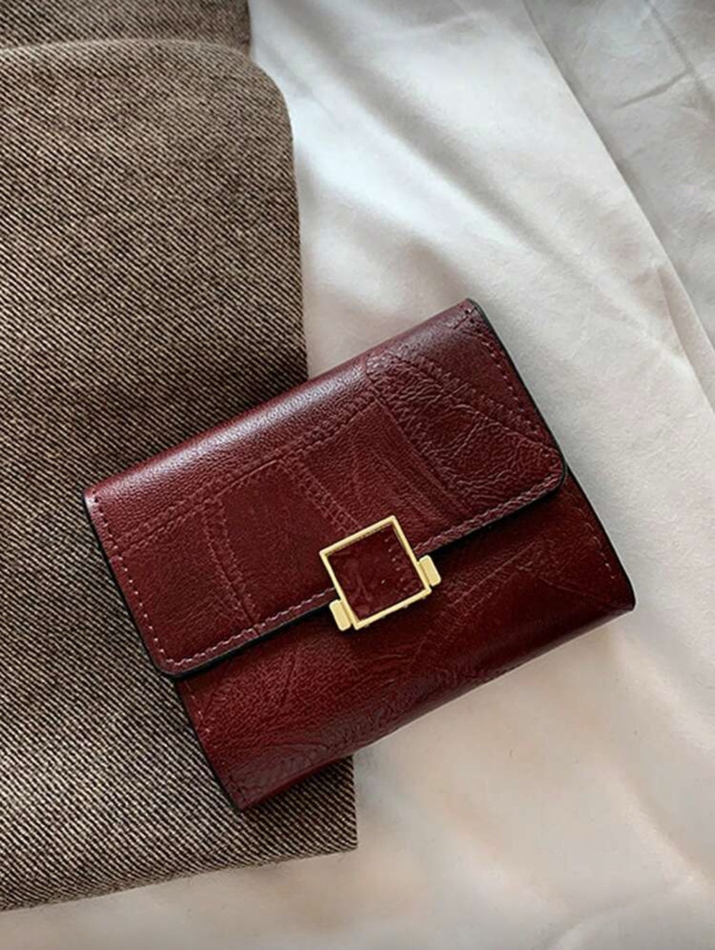 Burgundy buckle compact wallet front view