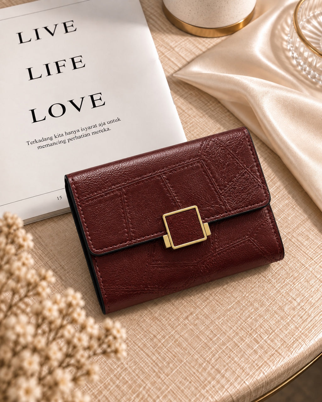 Burgundy buckle compact wallet on cream table setting