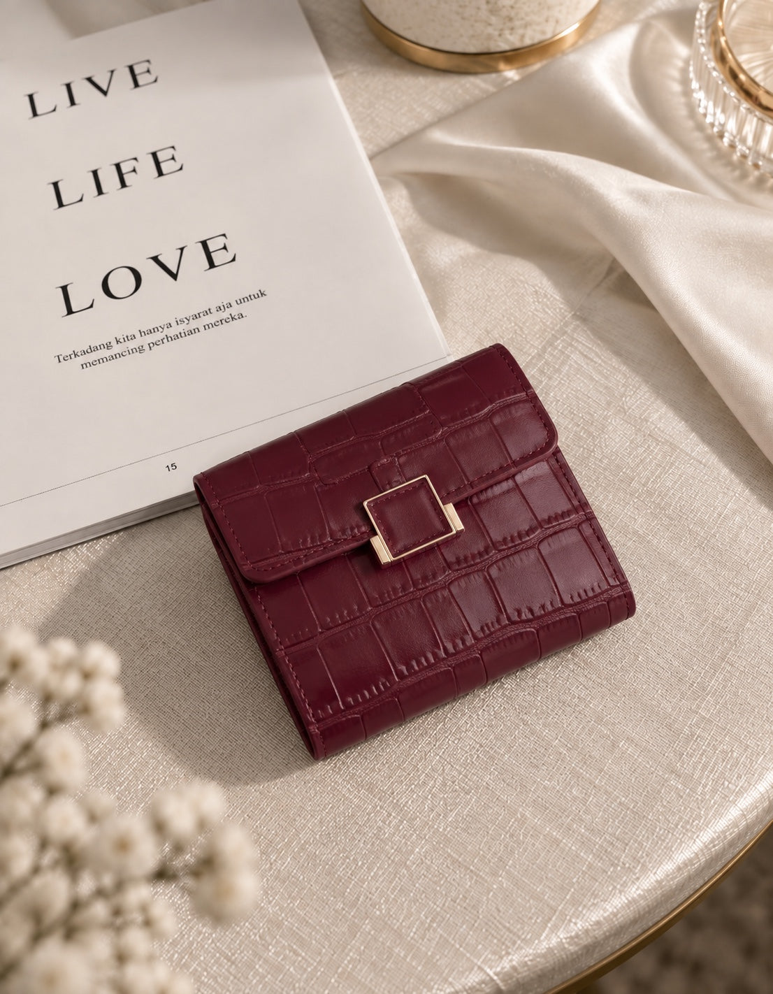 Burgundy crocodile texture compact wallet on cream table setting