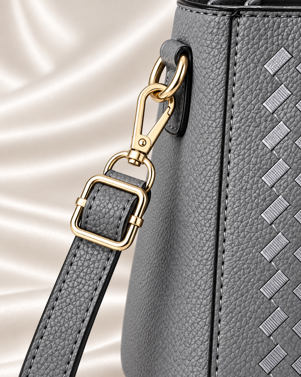 Gray handbag shoulder strap and gold buckle detail