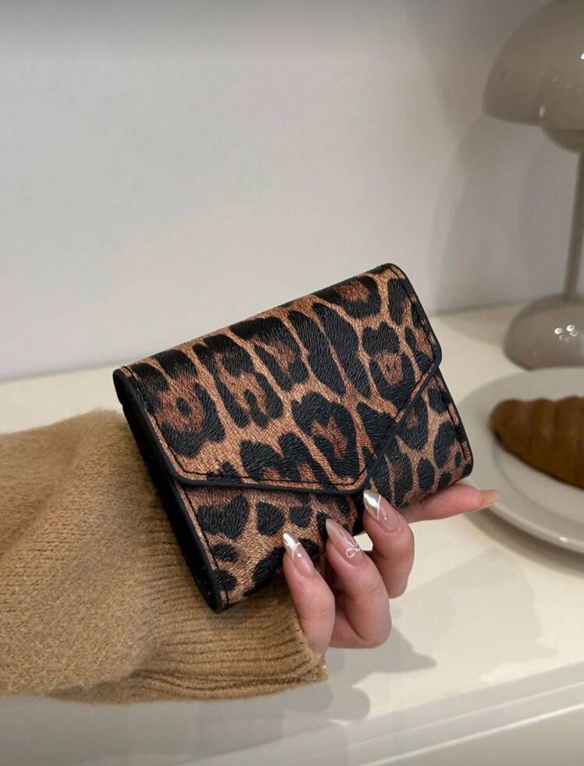 Leopard print envelope wallet held in hand