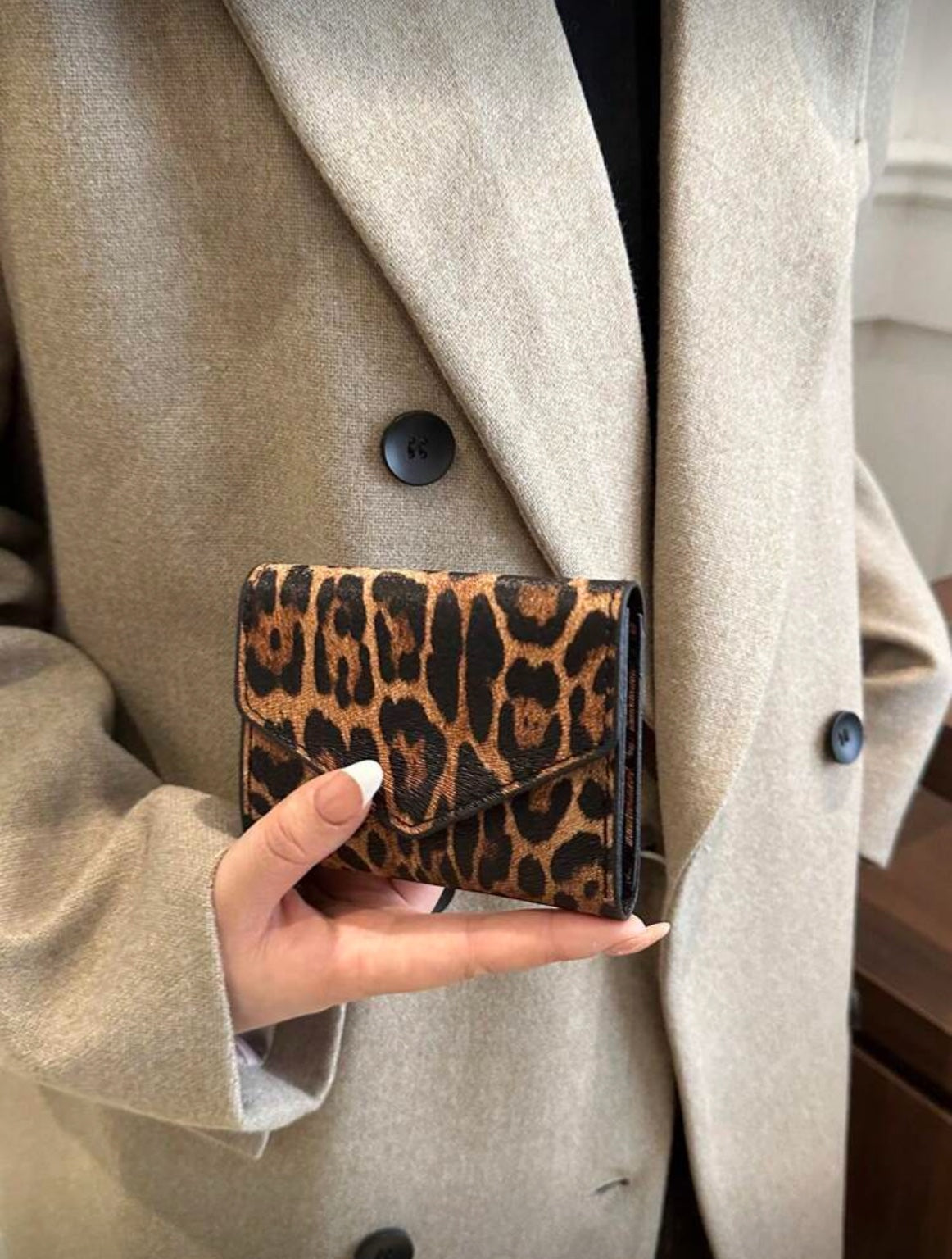 Leopard print envelope wallet styled with neutral outfit