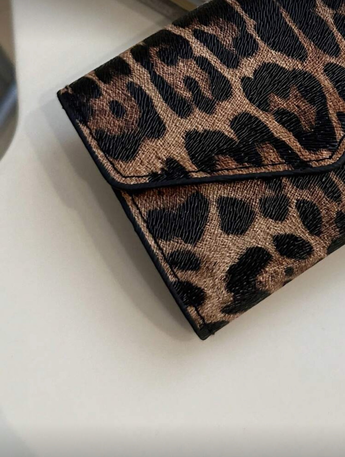 Close-up of leopard print wallet texture and black edging
