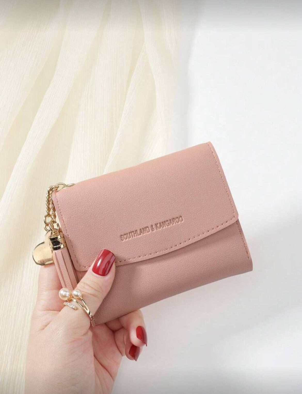 Pink compact wallet with tassel front view