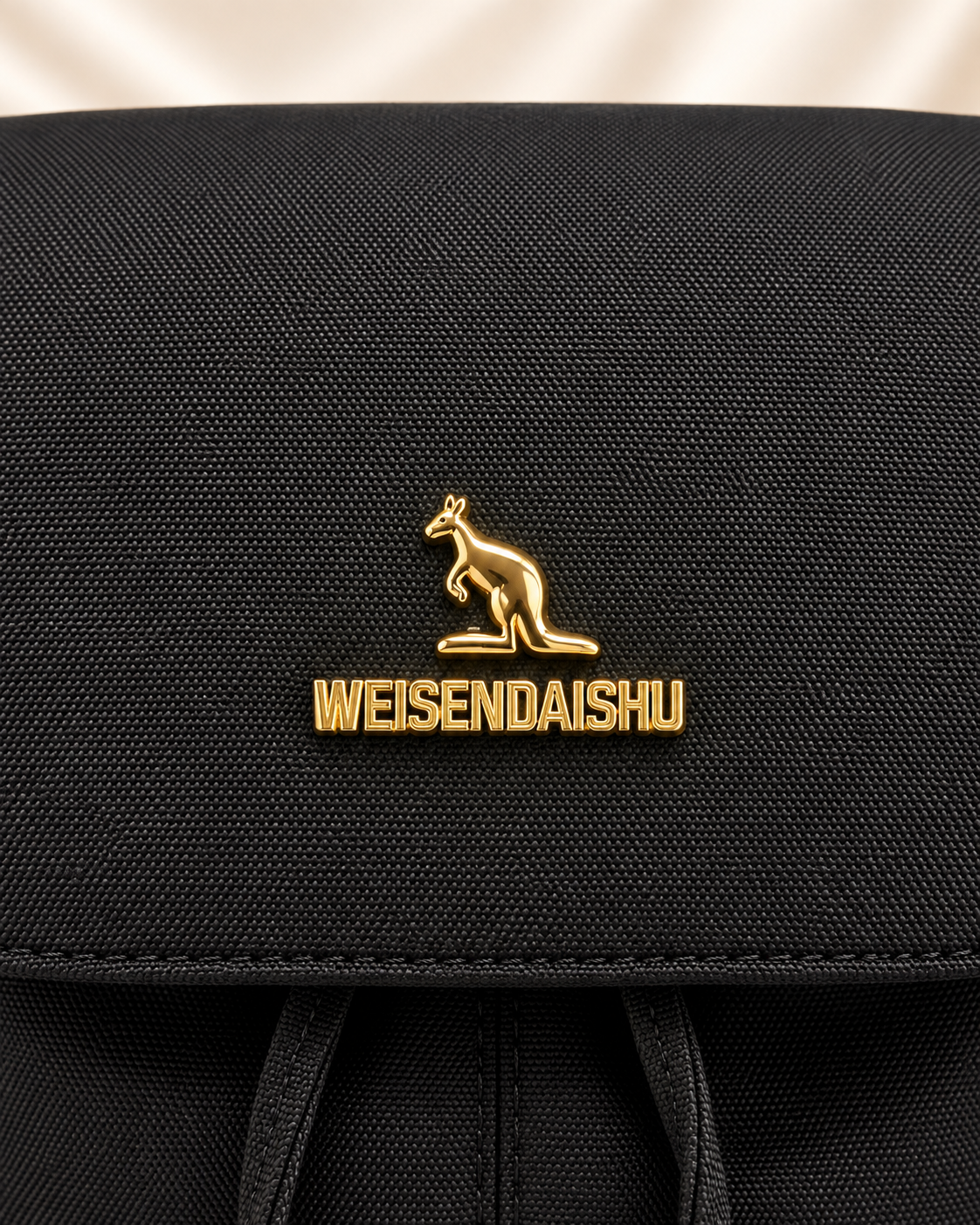 Gold kangaroo logo detail on black backpack