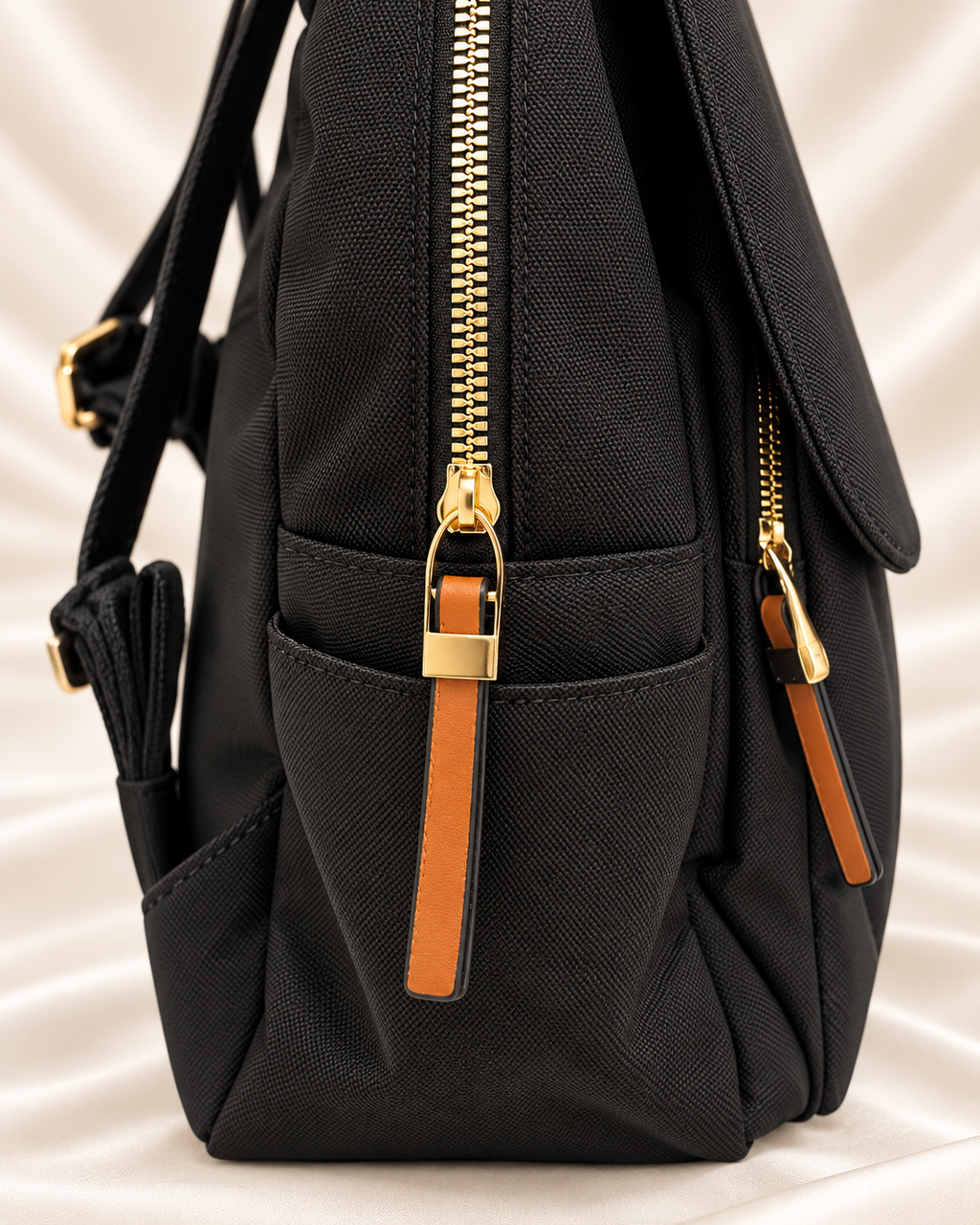 Black backpack side pocket and gold zipper detail