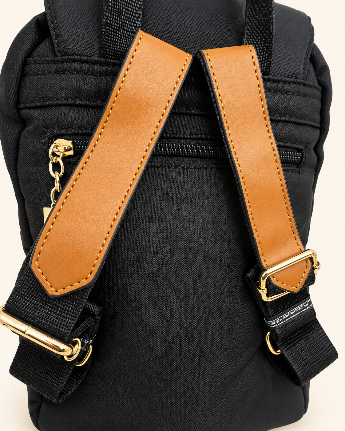 Black backpack shoulder straps and gold hardware detail